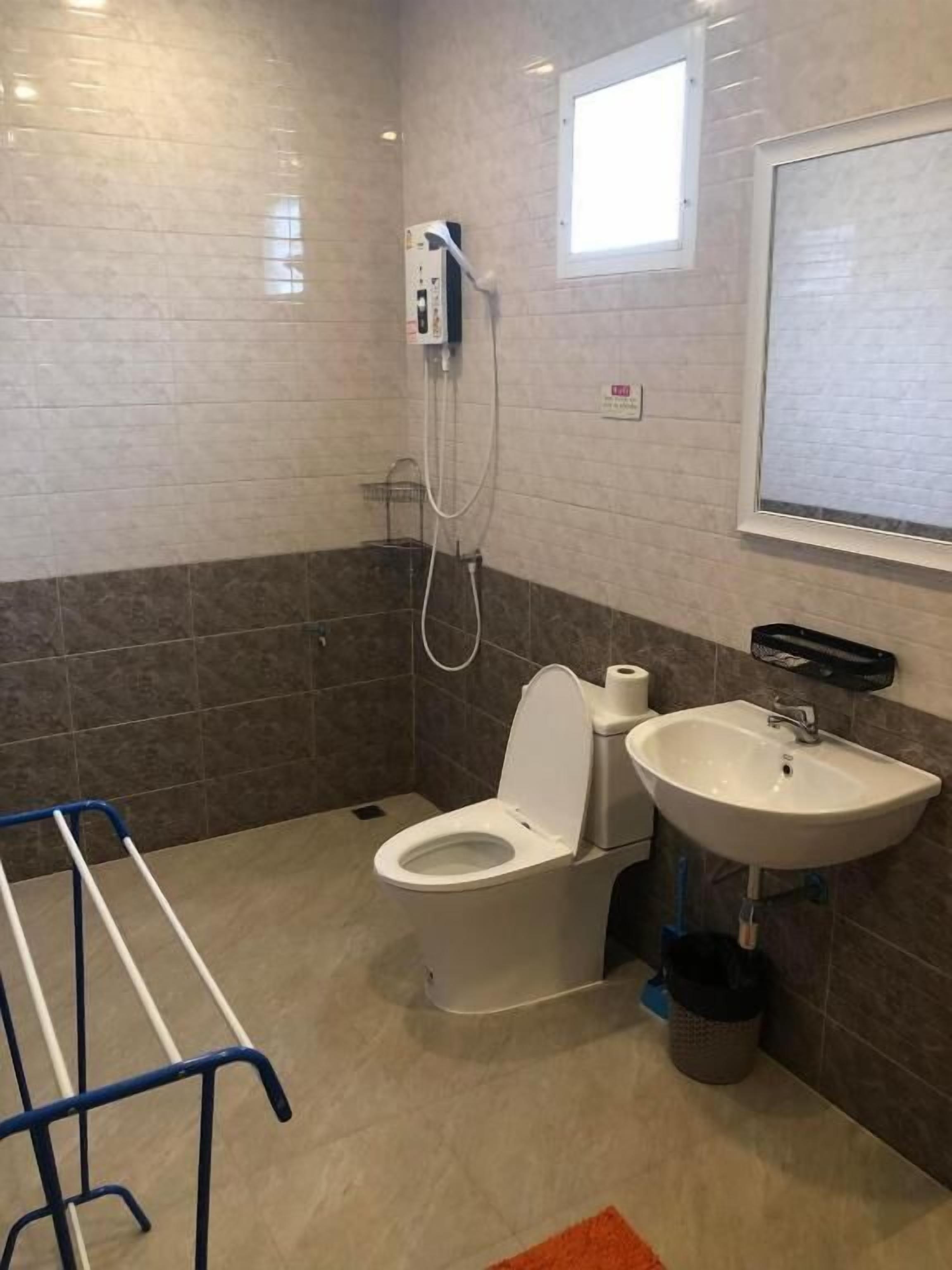 Un baño con inodoro, lavamanos y ventana.