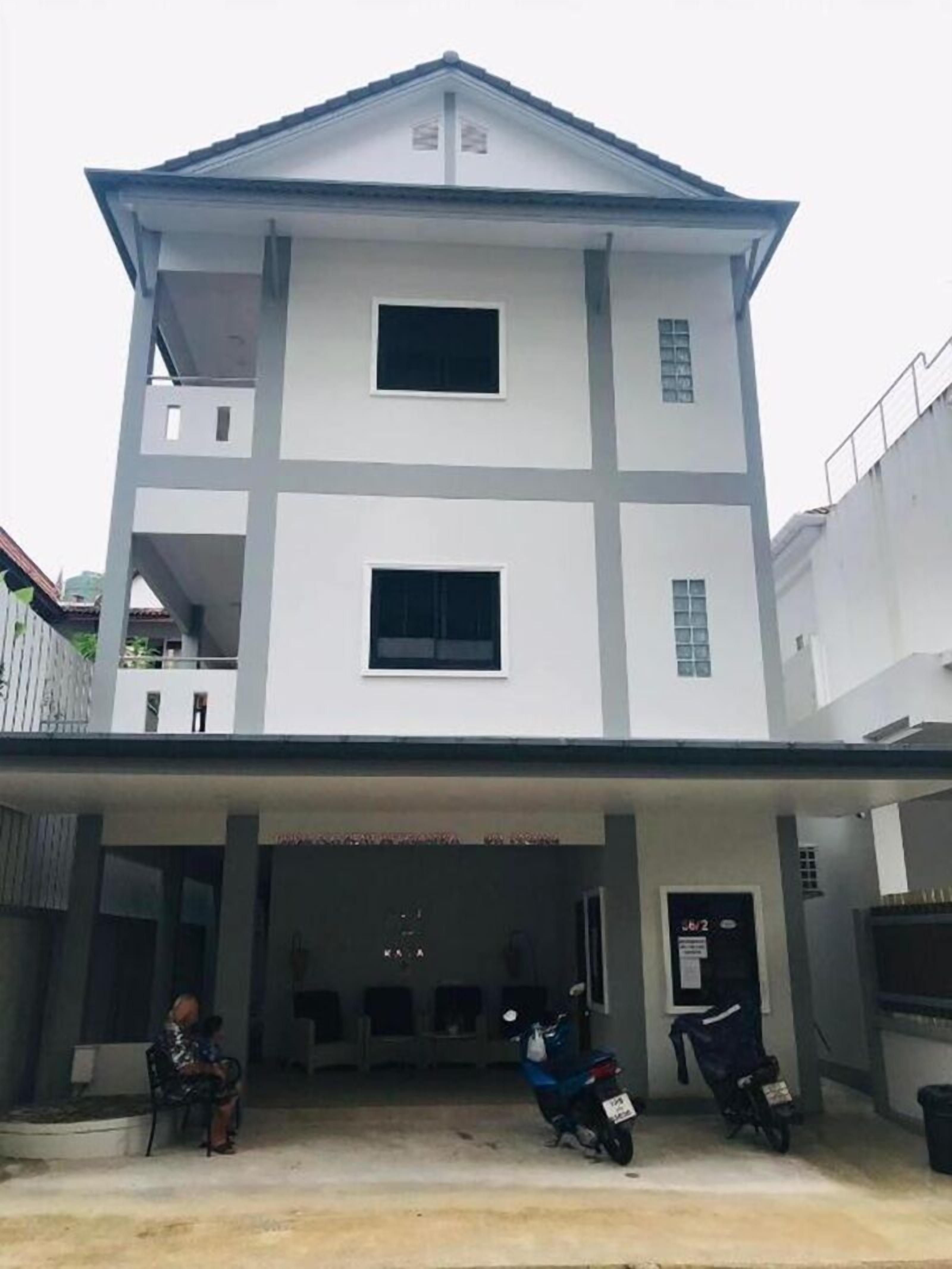 A two-story building with a flat roof and a balcony on the upper floor.