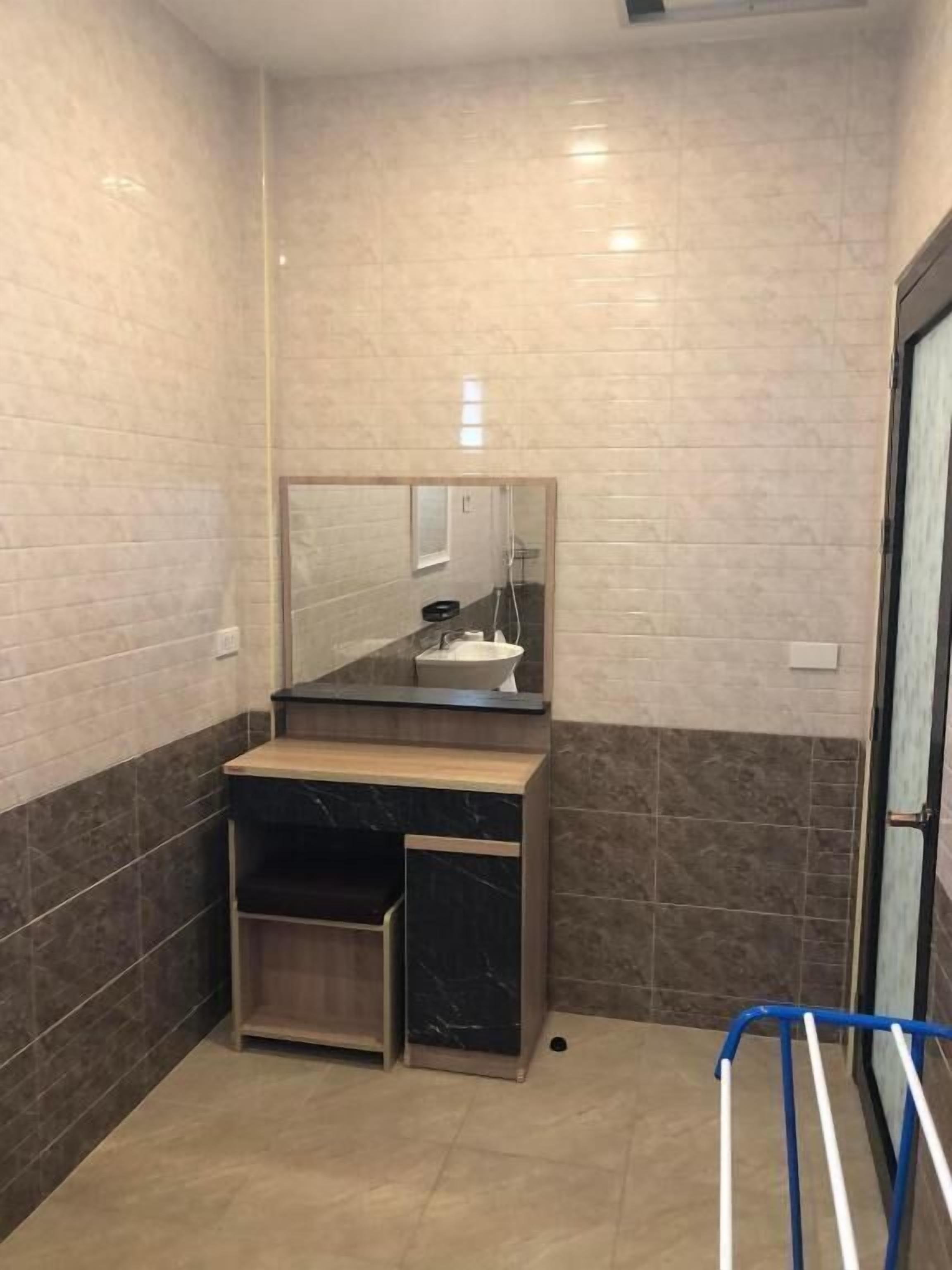 A bathroom with a marble vanity, a sink, and a mirror.