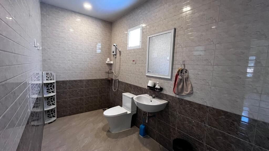 A bathroom with a toilet, sink, and shower.