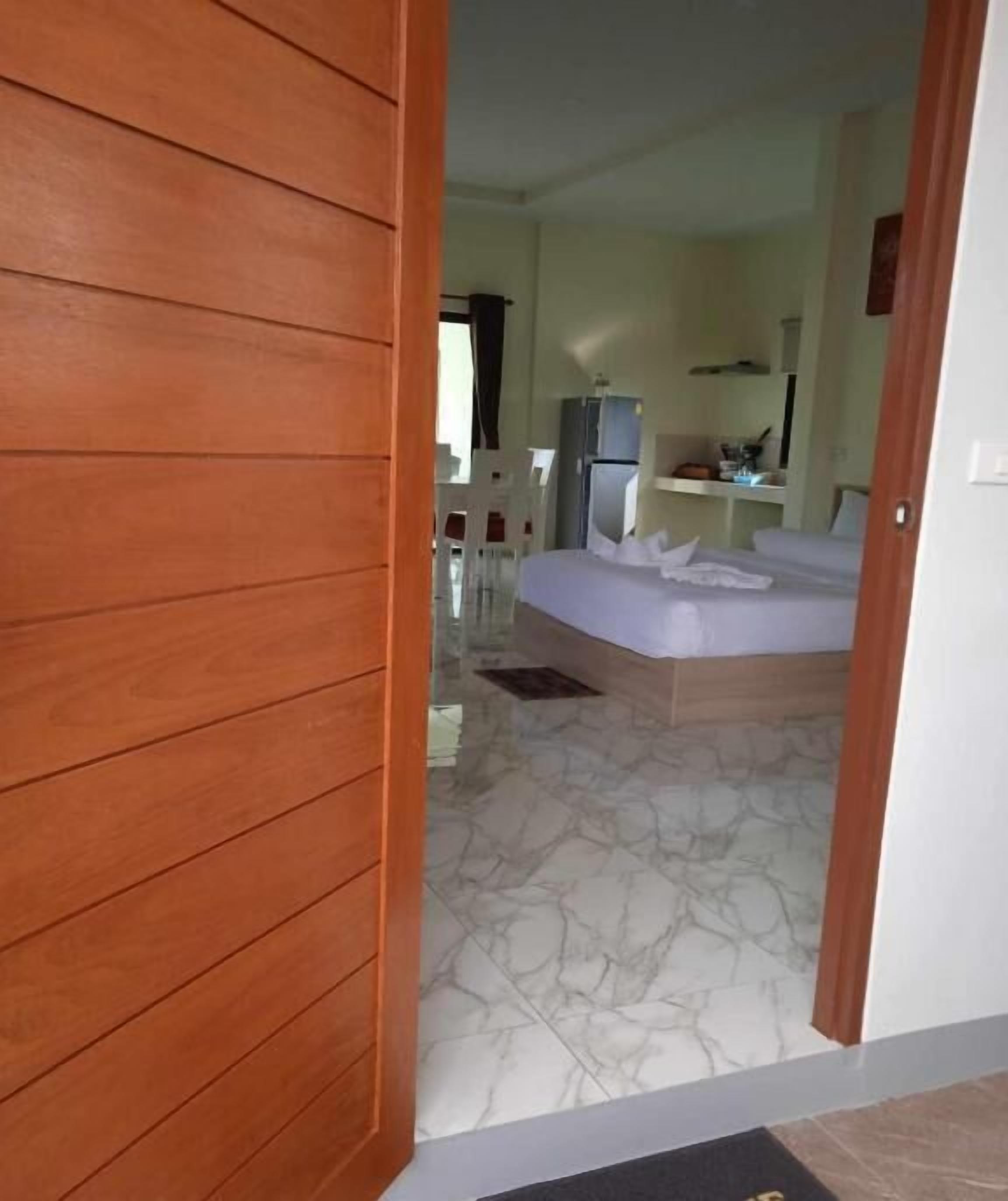 A hotel room with a bed, a small desk, and a chair.