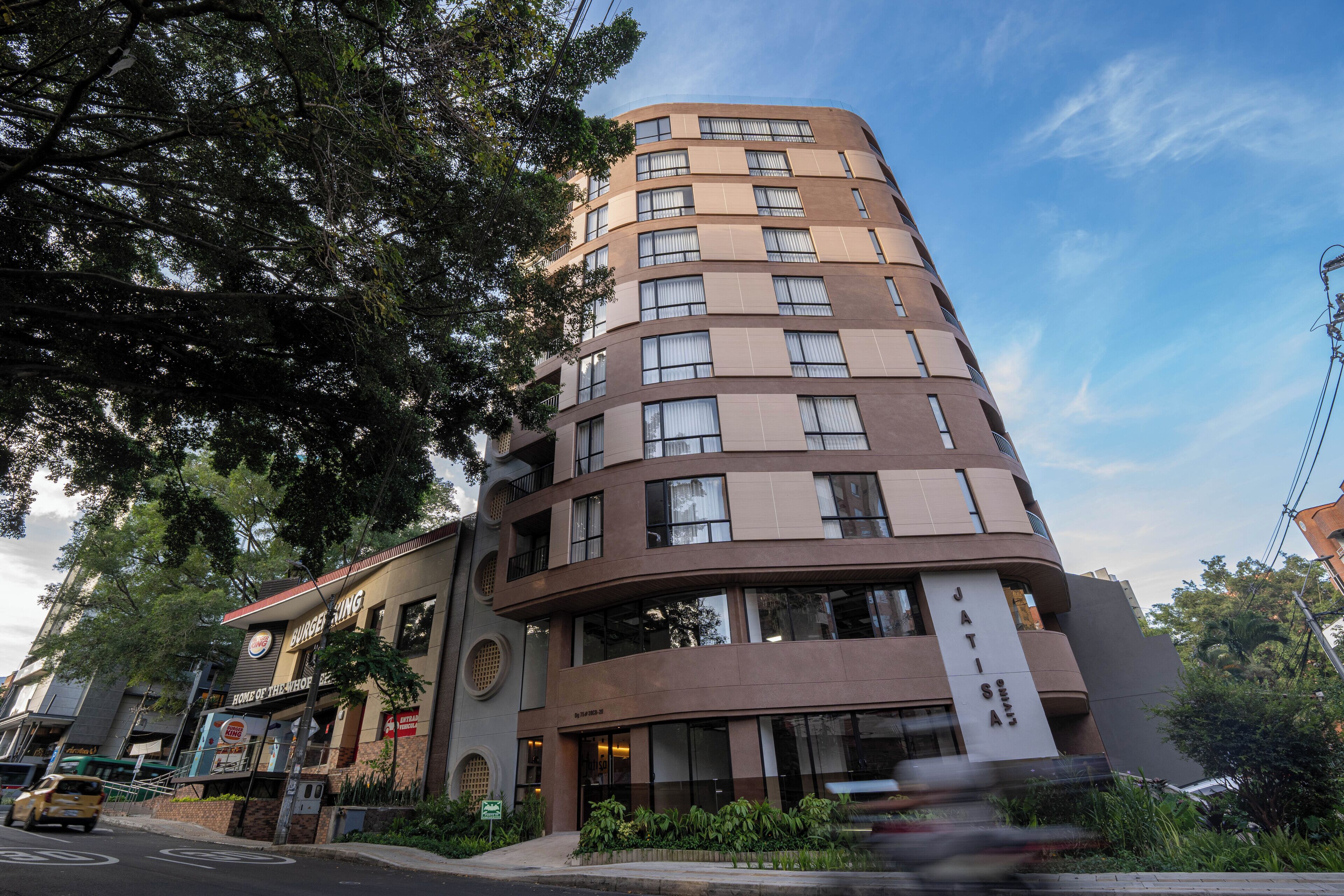 A multi-story hotel with a curved facade, large windows, and a sign for a restaurant.