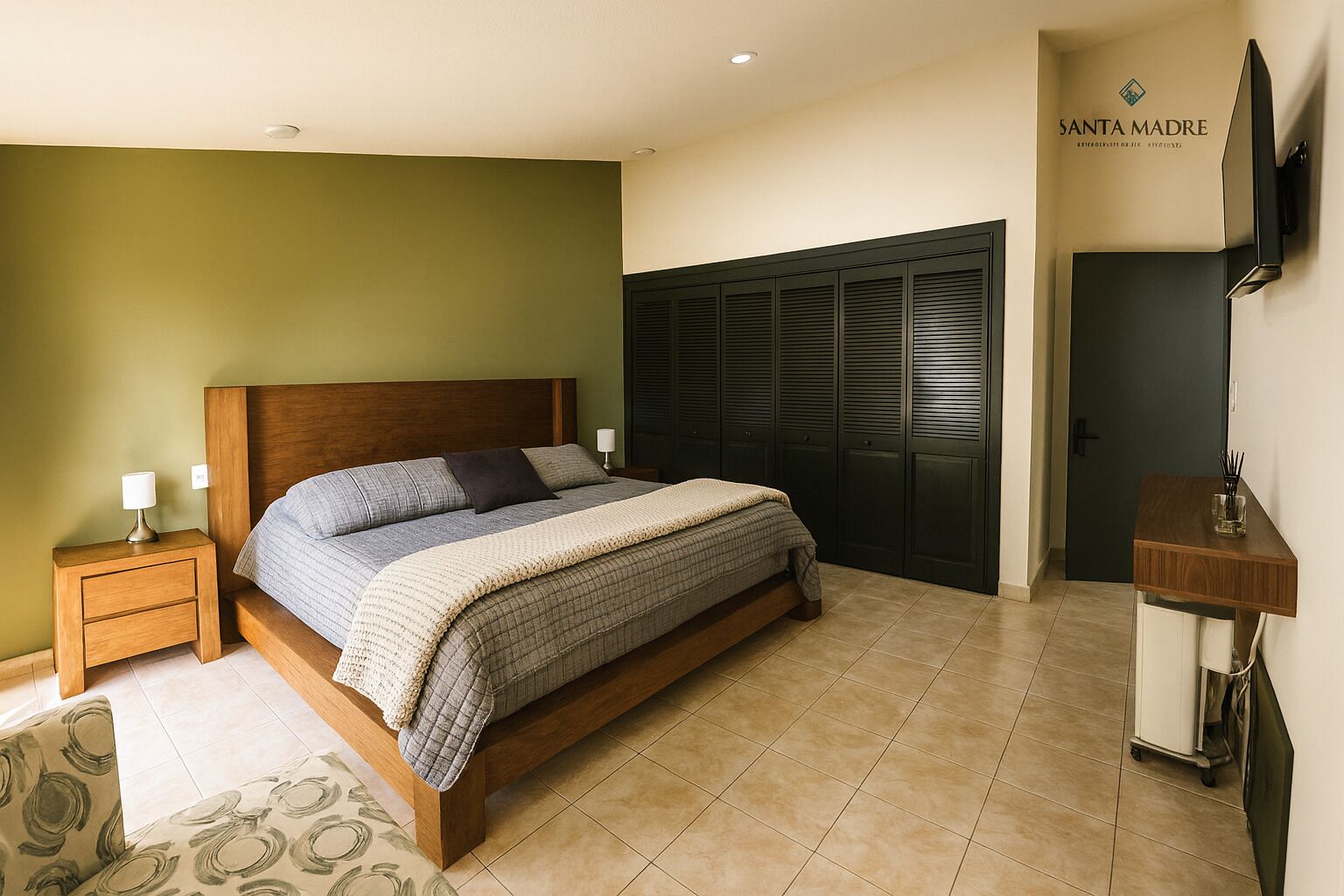 Un dormitorio con cama, mesitas de noche, armario y televisor montado en la pared.