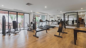 A spacious gym with various exercise equipment, large windows, and a wooden floor. - 1BR Condo Pool 5min Walk to Beach C131 (Choeng Thale)