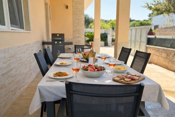 A dining table set for a meal with various dishes and drinks.