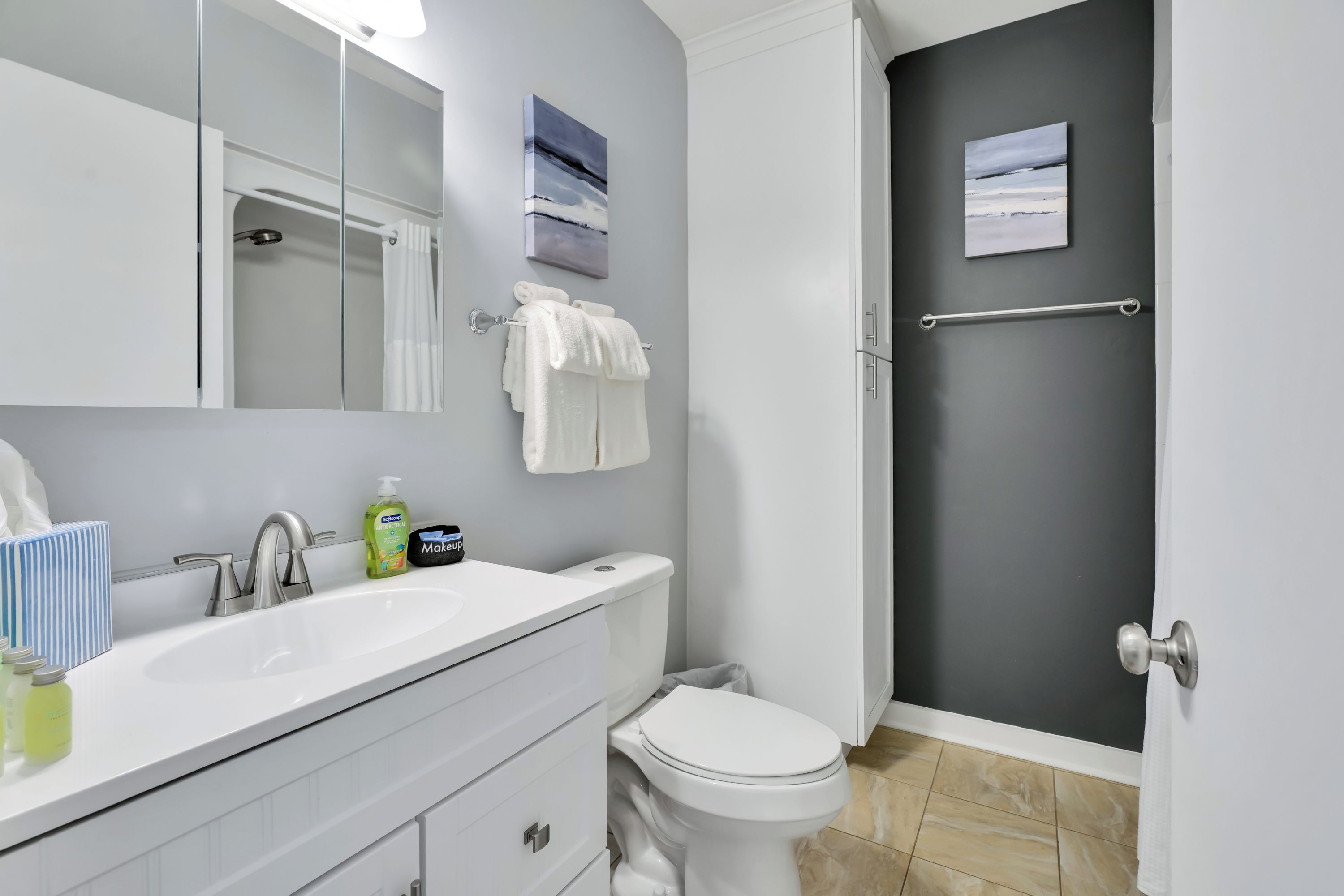 Une salle de bain moderne avec un lavabo blanc, des toilettes, une douche et un porte-serviettes.
