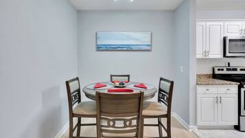 A modern kitchen with white cabinets, a granite countertop, and stainless steel appliances.