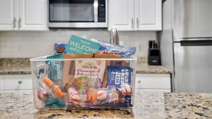 Una cocina con armarios blancos, un refrigerador de acero inoxidable y una encimera de granito.