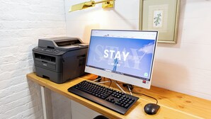 A computer desk with a printer, keyboard, and mouse. - Compact Queen Retreat @ Times Square (New York)