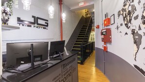 A reception desk with a computer, a world map on the wall, and a staircase in the background. - King Room, Heart of Times Square (New York)