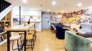 A modern interior with a wooden bar area, seating, and a wall adorned with photos. - King Room, Heart of Times Square (New York)