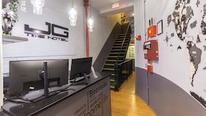 A reception desk with a computer, a world map on the wall, and a staircase in the background.