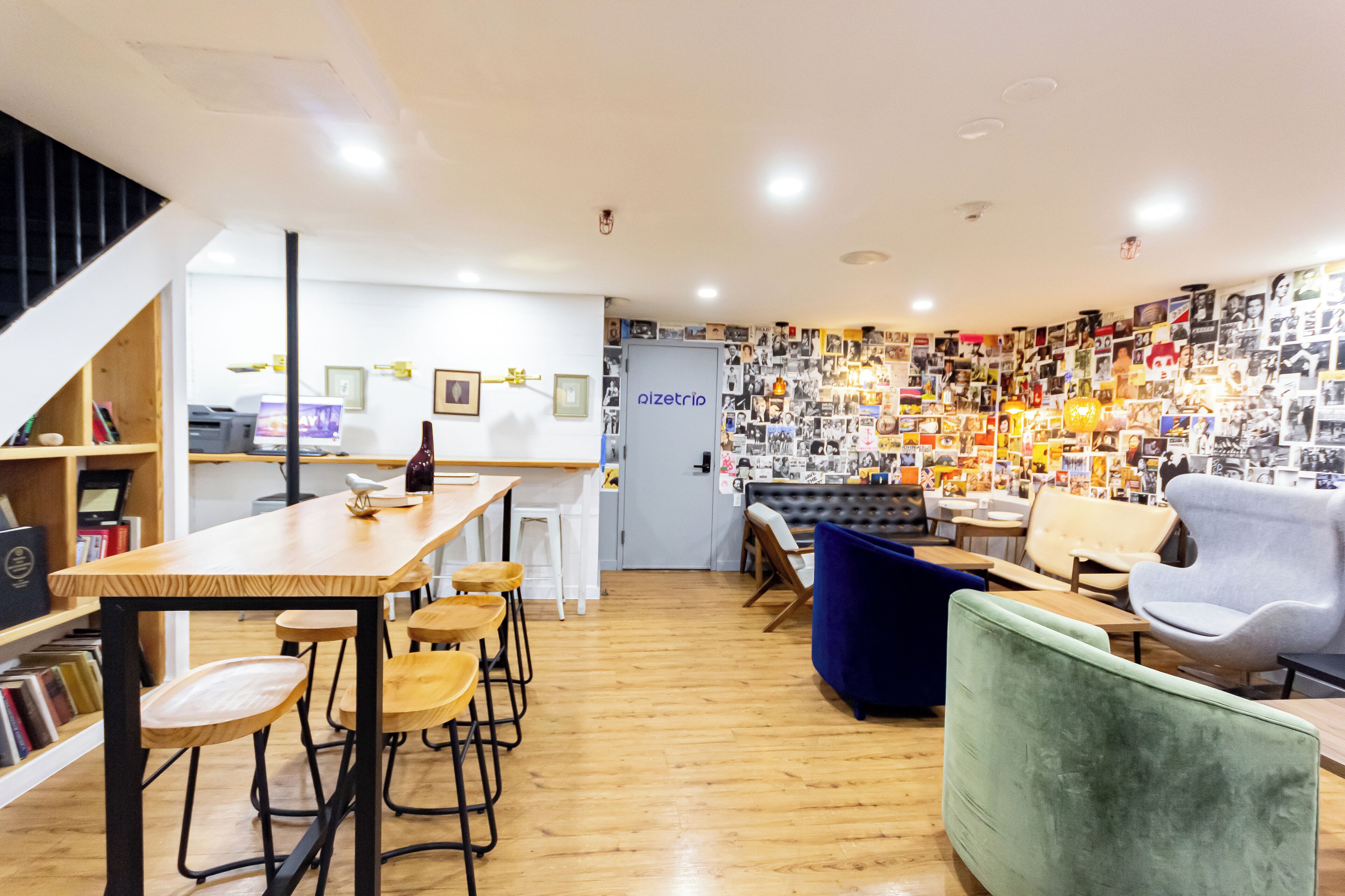 A modern interior with a wooden bar area, seating, and a wall adorned with photos.