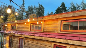 A wooden cabin with multiple windows and a deck area. - Tiny house on Organic Farm - Quiet & Clean w Fast wifi 3bd/1ba (Skokomish)