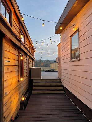 Un bâtiment en bois doté d’une terrasse en bois et décoré de guirlandes lumineuses.