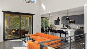 A modern kitchen with a central island, bar seating, and a large dining area with a glass partition. - Peaceful Resort-Sauna/Hot Tub/Gym/Fire Pit (Cle Elum)
