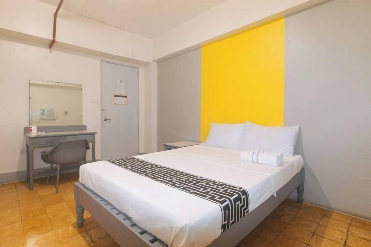 Un dormitorio con cama, escritorio y silla.