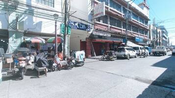A street with shops and parked vehicles.