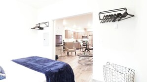 Una sala de estar moderna con un sofá azul, un comedor con mesa de vidrio y una cocina al fondo.