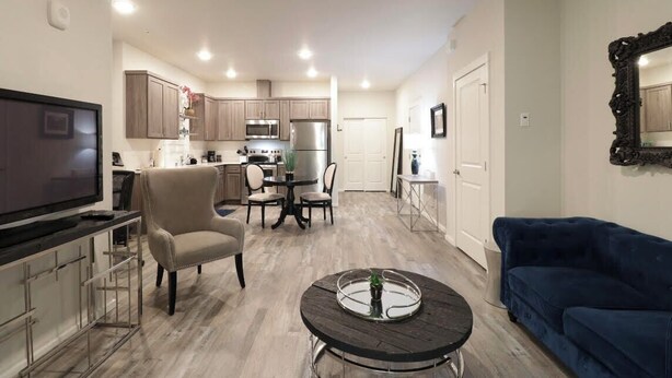 Un apartamento moderno con sala de estar, comedor, cocina y televisor.