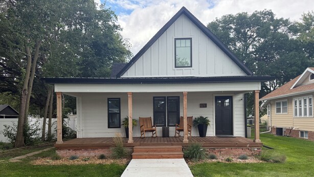 A single-story house with a front porch, a small deck, and a well-maintained lawn.