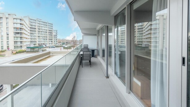 Un balcone con vista su un parcheggio e degli edifici.