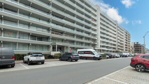 Un edificio a più piani dal design moderno, caratterizzato da una serie di balconi e un ingresso ben visibile.