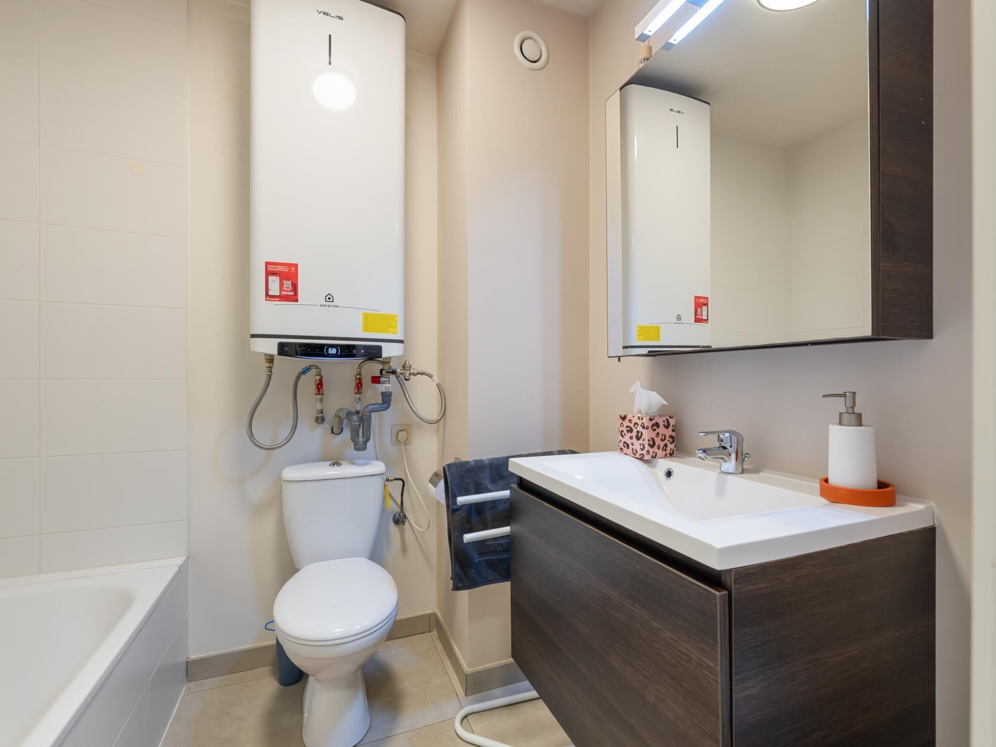 A modern bathroom with a toilet, sink, and bathtub.