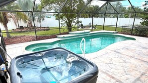 A hot tub in a backyard with a swimming pool, surrounded by a fence and palm trees. - Bring Kids & the Dog! House, Fence + Bunkhouse (Port Charlotte)