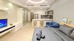 A modern hotel room with a bed, a TV, a desk, and a kitchenette. - M city service suite KLCC (Kuala Lumpur)