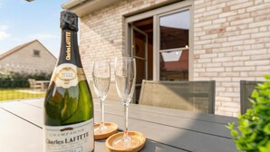 Eine Flasche Charles Lafitte Champagner auf einem Tisch mit zwei Gläsern und Untersetzern.