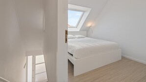 A bedroom with a skylight, a bed, and a wooden floor. - Cosy holiday home on the Westhinder domain (Koksijde)