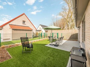 A patio with outdoor furniture, a green umbrella, and a grill. - Holiday home on park, pets allowed (Koksijde)
