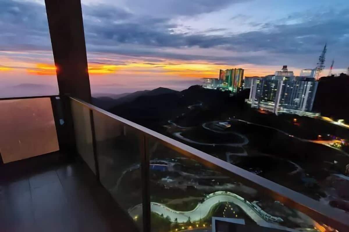 A balcony with a view of a cityscape during sunset.