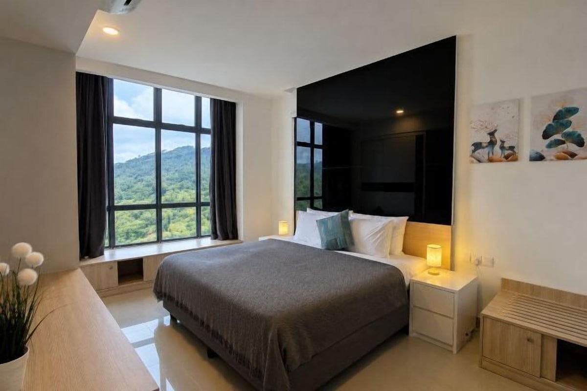 A modern bedroom with a large bed, bedside tables, a window with a view, and artwork on the wall.