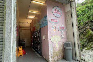 A storefront with a pink wall, a sign that reads 'Iona's Sariang,' and a trash bin. - Emerald Homes Cozy Homestay @ Genting Highlands (Genting Highlands)