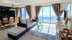 A modern living room with a sofa, coffee table, and dining area. - Emerald Homes Cozy Homestay @ Genting Highlands (Genting Highlands)