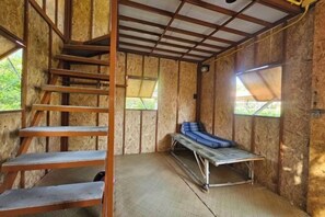 A room with a wooden staircase, a bench, and a window.