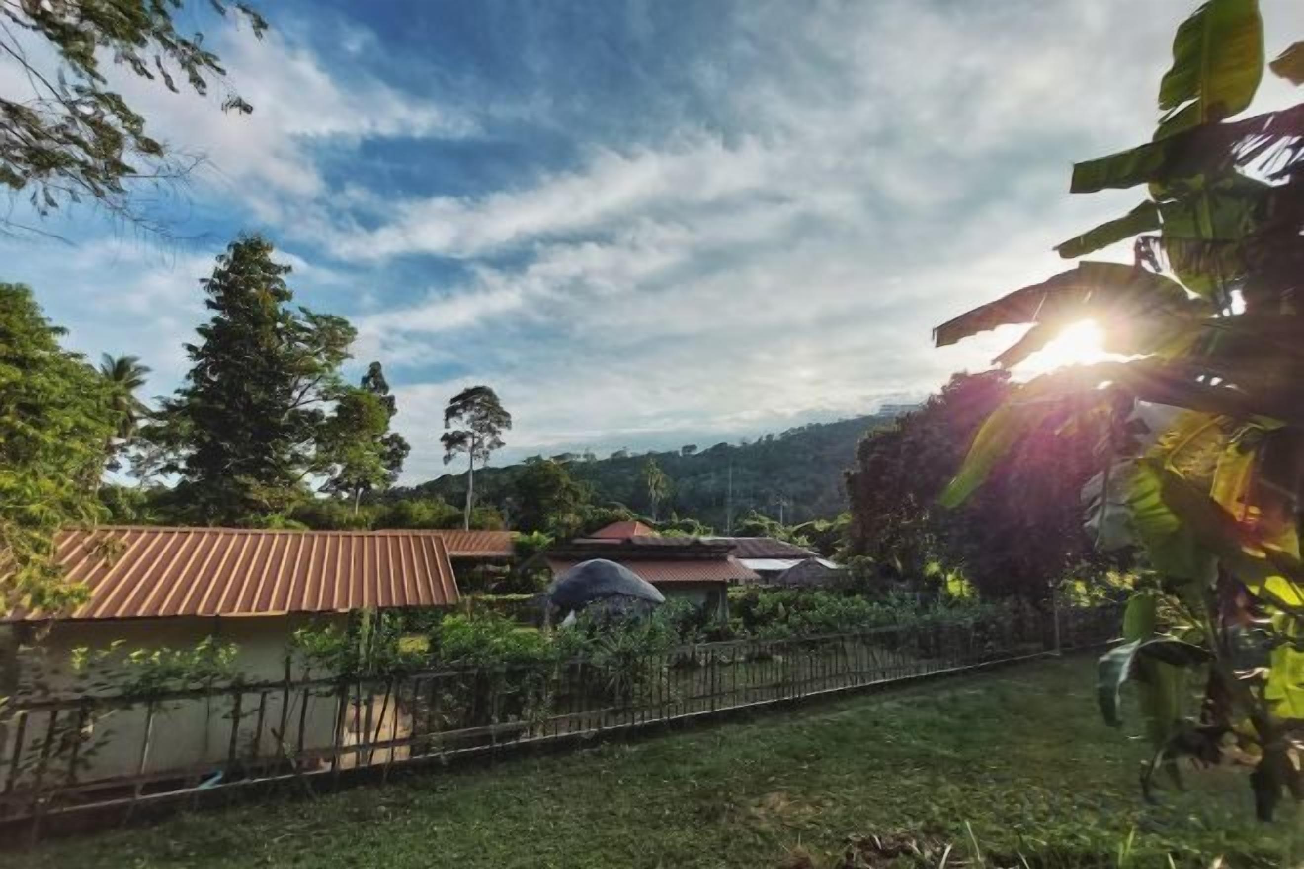 Un barrio residencial con casas, un patio cercado y cielo despejado.