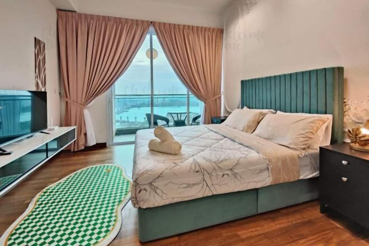 Une chambre d’hôtel moderne avec un grand lit, une télévision et une vue sur la ville.