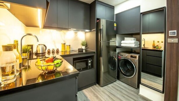 Cocina compacta con horno integrado, microondas y lavadora.