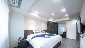 Un dormitorio moderno con una cama grande, un armario de madera oscura y un televisor de pantalla plana.