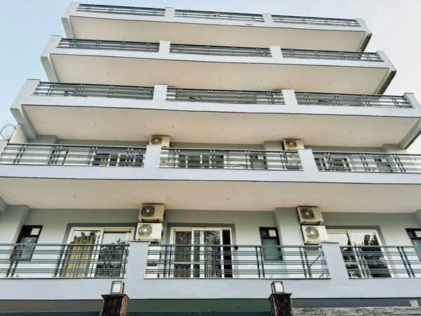 A multi-story building with balconies, air conditioning units, and a modern architectural design. - MOZO Banquet and Conference Hall Gurgaon (Gurugram)