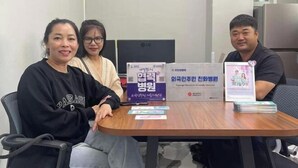 A meeting room with a wooden table, chairs, and a few promotional materials. - GwangJu SunFlower Hostel (Gwangju)