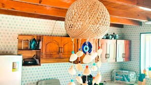 Una cocina con armarios de madera, una estufa a gas y un adorno colgante.