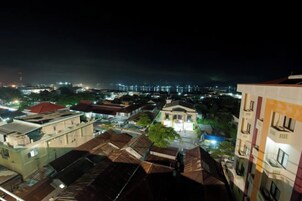 Vista nocturna de un paisaje urbano con edificios y un horizonte lejano.