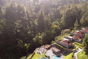 A resort with multiple buildings, a swimming pool, and lush greenery surrounding the property. - Joglo Ageng Guci Tegal (Bumijawa)