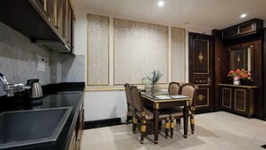 Een eethoek met een tafel en stoelen, een keukenblad en een decoratief wandpaneel.
