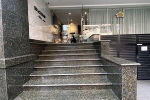 A set of marble stairs leading to a lobby area with a reception desk and a glass partition. - Nicecy Apartment - Sai Gon City (Ho Chi Minh City)