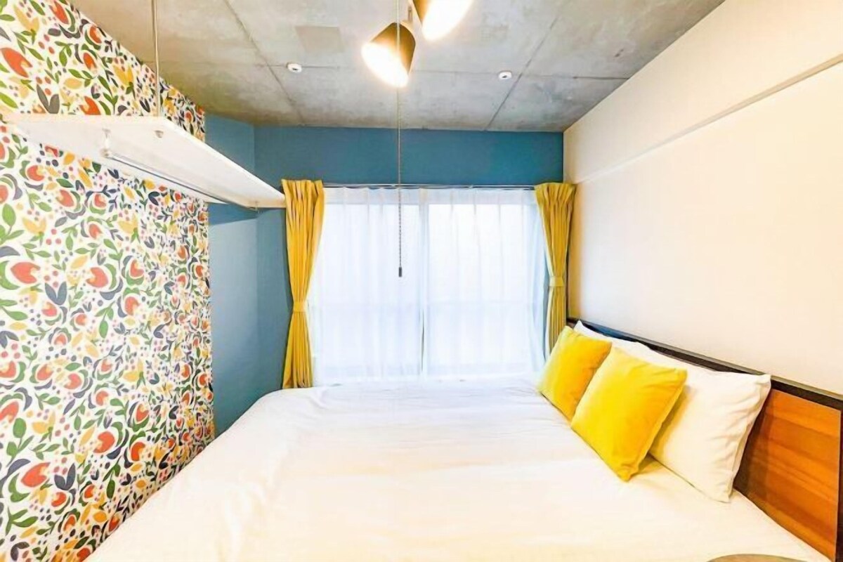 A hotel room with a bed, curtains, and a window with a view.
